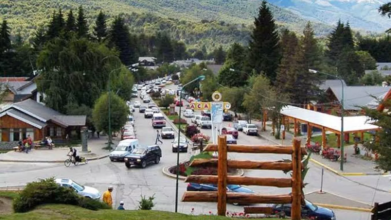Centro de Villa La Angostura durante o verão, com ruas movimentadas e casas de estilo patagônico.