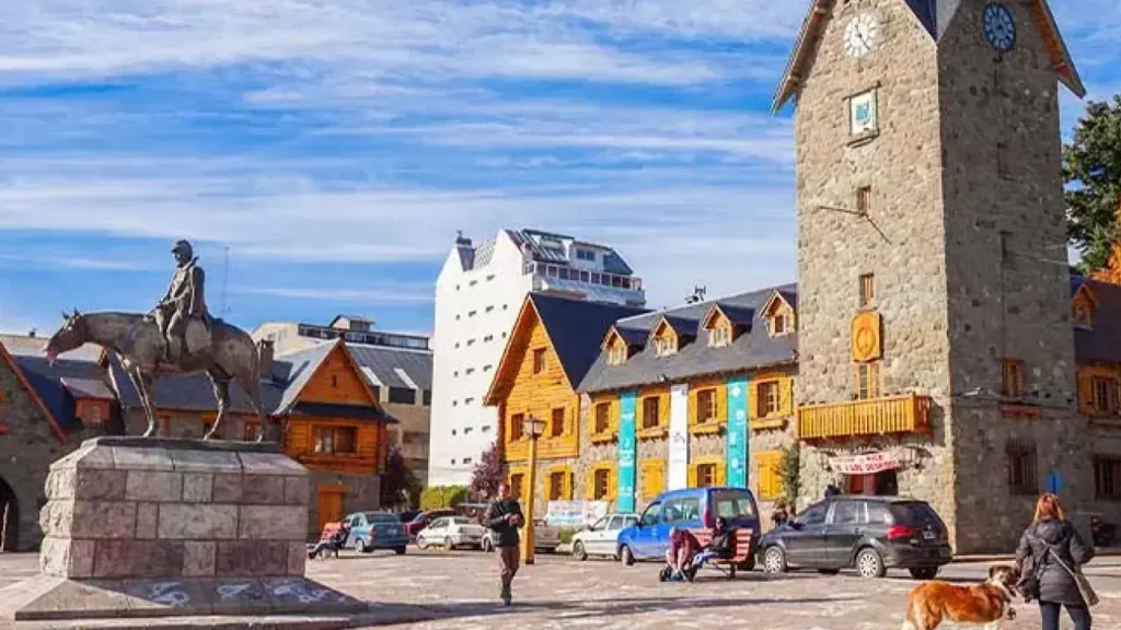 Praça do Centro Cívico de Bariloche com torre do relógio e estátua equestre.