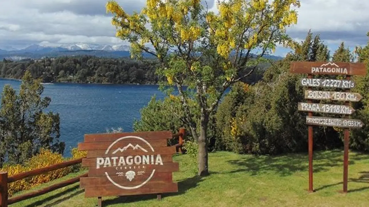 Mirante da Cervejaria Patagonia em Bariloche com vista para lago e montanhas, placa de madeira com o logo.