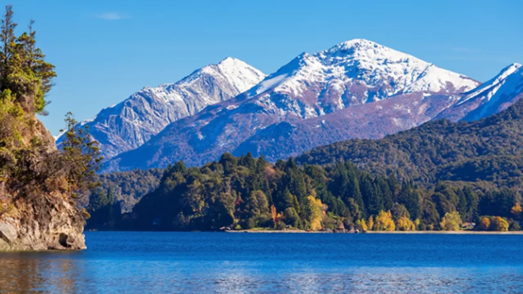 Lago Nahuel Huapi em Bariloche com montanhas nevadas ao fundo.