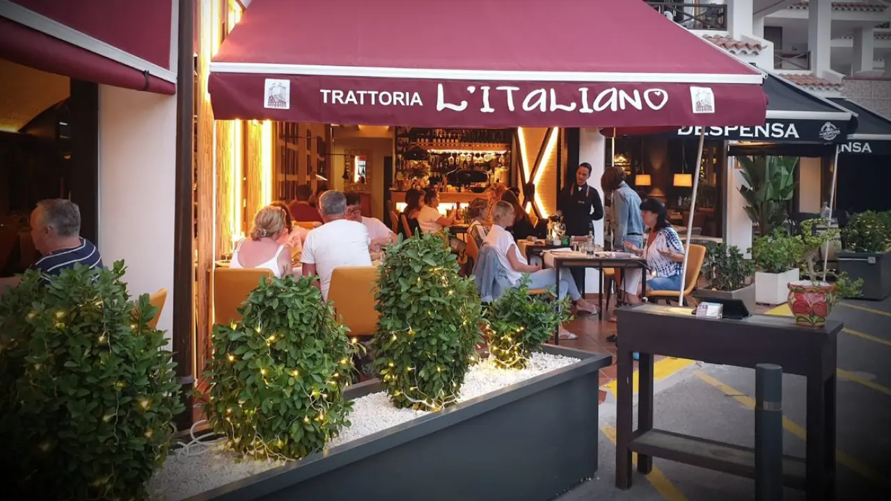 Fachada da Trattoria L’Italiano em Bariloche com clientes jantando na área externa.
