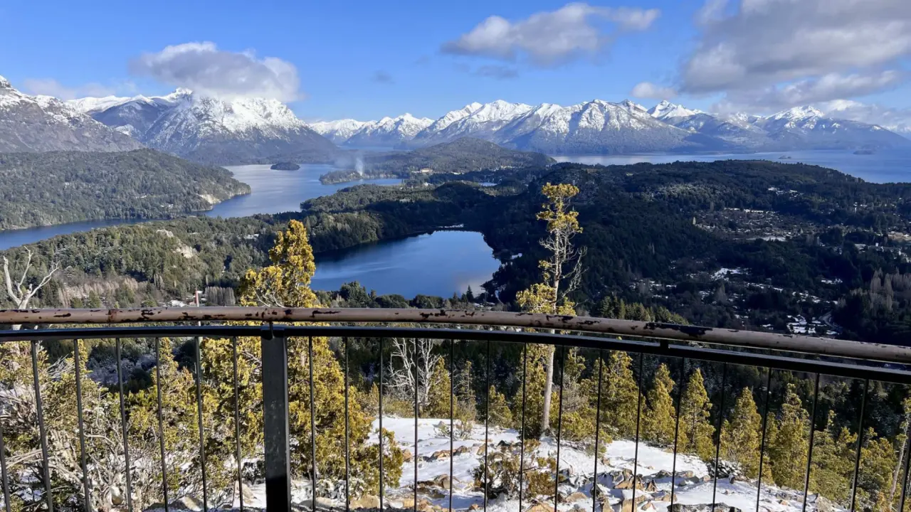 Paisagem panorâmica do mirante Cerro Campanario, com lagos, florestas e montanhas nevadas em Bariloche, Argentina.