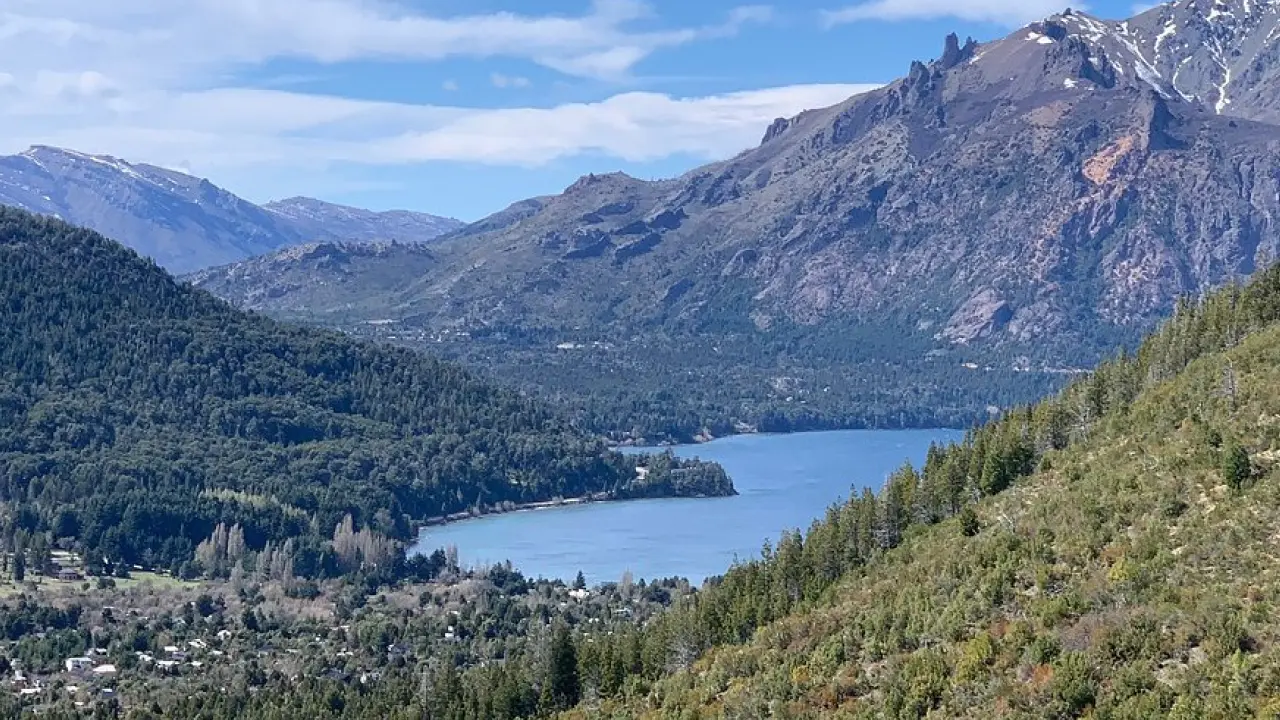 Paisagem montanhosa com lago e vegetação densa na região de Bariloche, na Patagônia argentina, durante o outono.