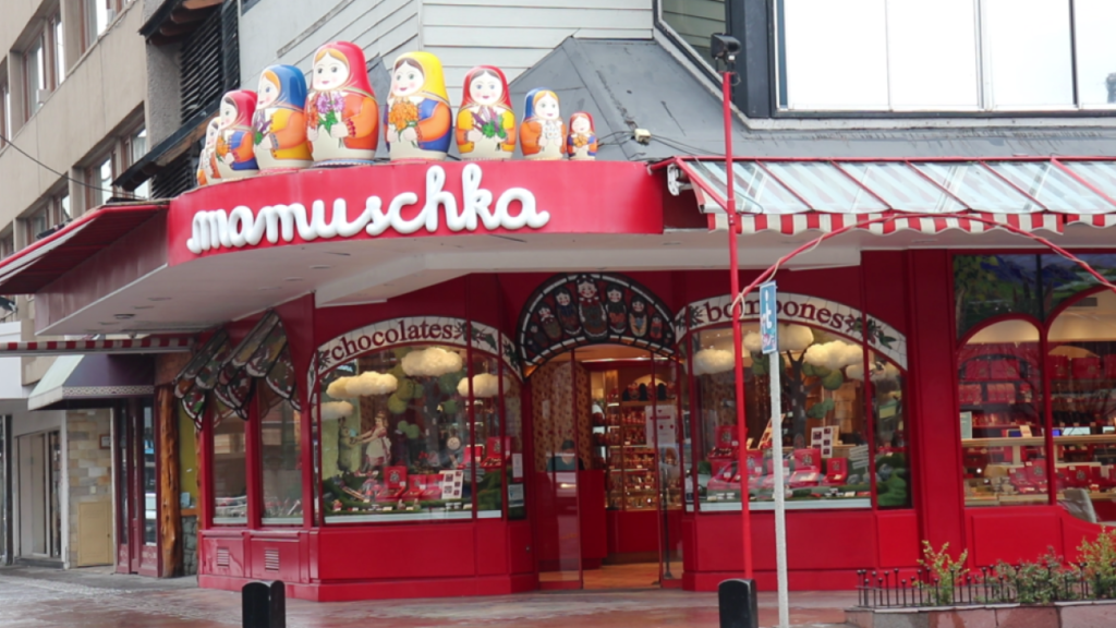 Fachada da loja Mamuscka em Bariloche, com vitrine colorida e bonecas russas decorativas no topo.