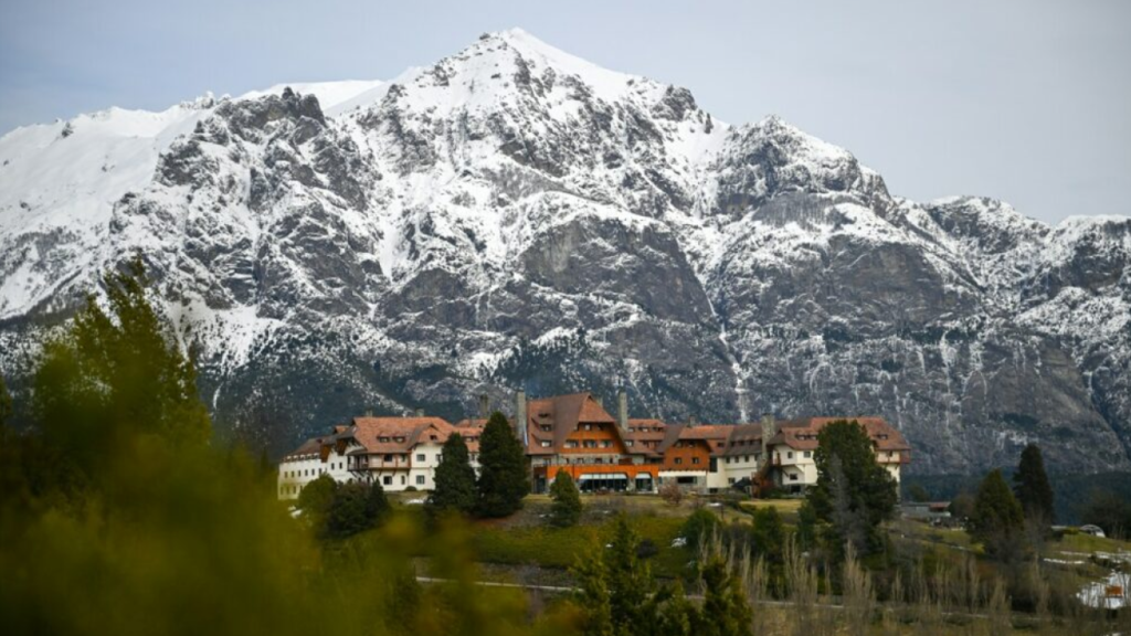 Hotel em Bariloche com montanhas nevadas ao fundo na primavera