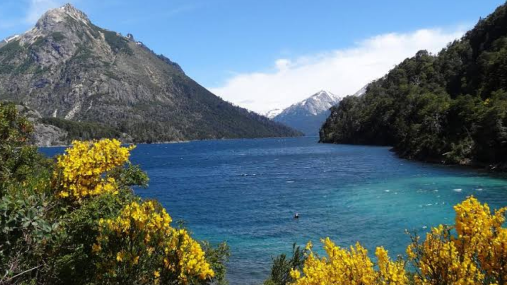 Panorama do Lago Nahuel Huapi visto de um mirante, mostrando a orla da cidade e as montanhas ao longe.