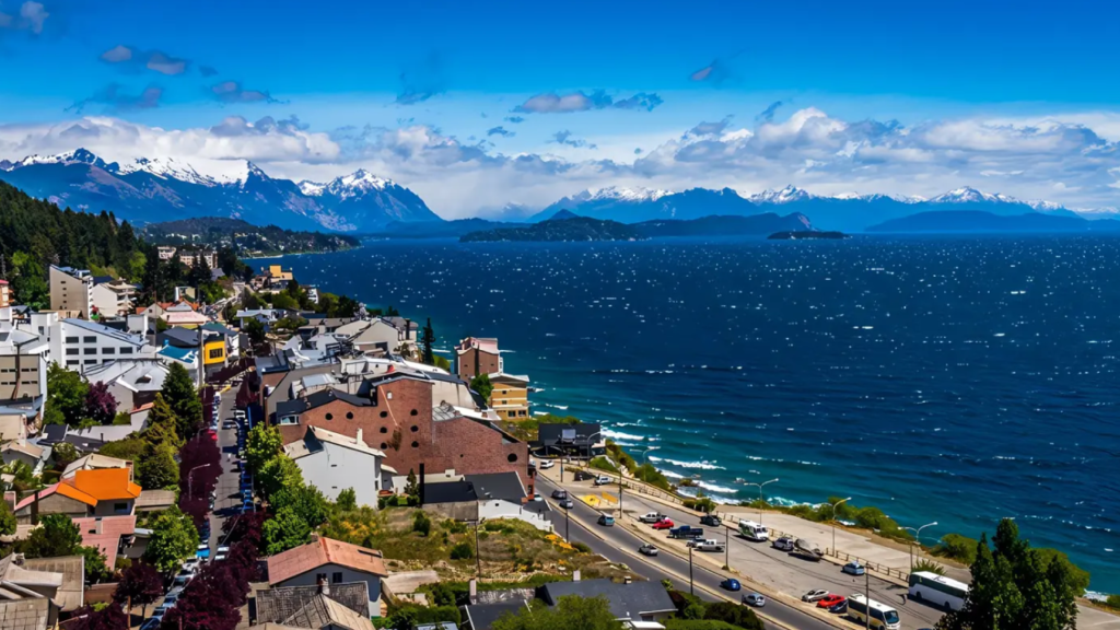 Vista panorâmica do centro de Bariloche com o lago Nahuel Huapi e montanhas nevadas ao fundo.