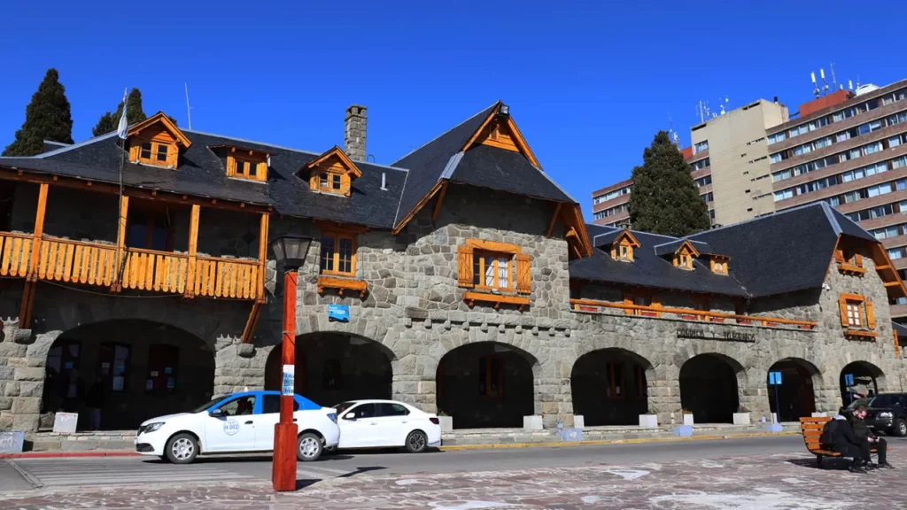 Un edificio de piedra y madera en Bariloche, con un cielo despejado y un toque de arquitectura alpina.