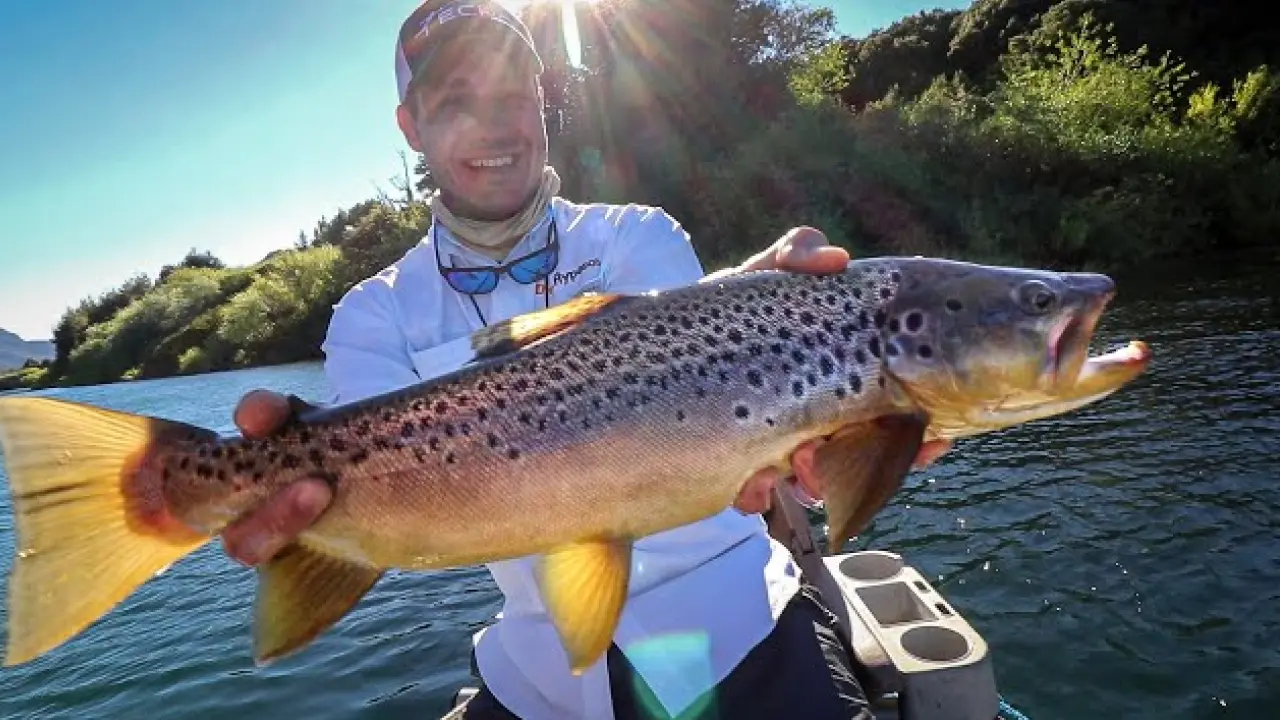 Turista segura uma truta gigante durante passeio de pesca esportiva em Bariloche, uma das atividades favoritas na região.