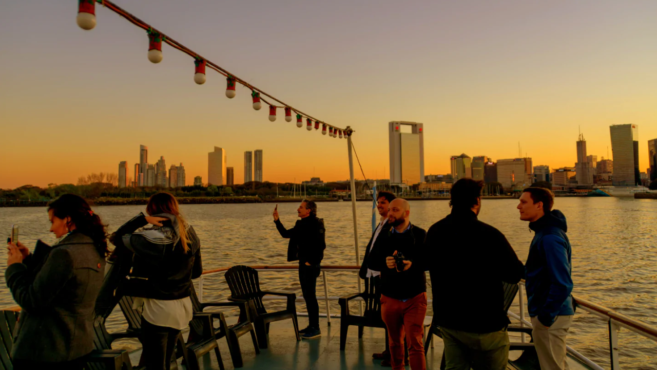Pôr do sol visto de um barco em Puerto Madero, skyline de Buenos Aires ao fundo.
